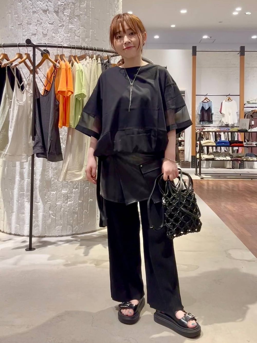 ブラック系のその他パンツ、ブラック系のサンダル、ブラック系のハンドバッグを着用したレディースの夏コーディネートの2枚目の写真