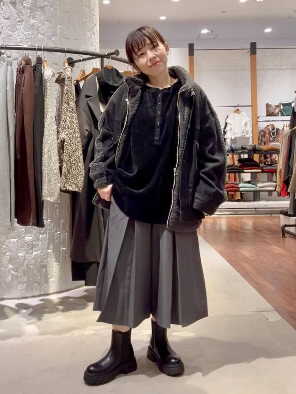 ブラック系のブーツ、ブラック系のデニムジャケット、ブラック系のハンドバッグを着用したレディースの秋コーディネートの4枚目の写真