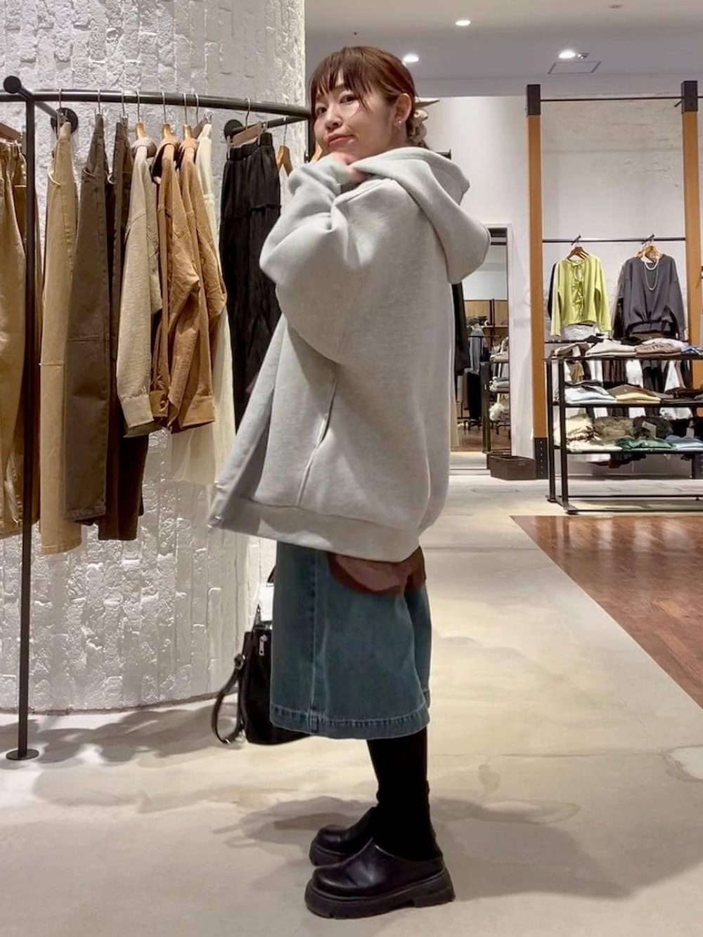 グレー系のパーカー、ブラック系のショルダーバッグ、ブラック系のその他シューズを着用したレディースの冬コーディネートの3枚目の写真