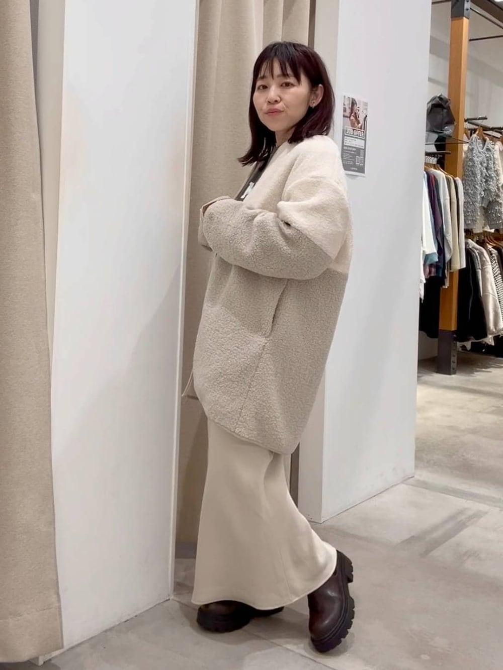 ホワイト系のスカート、ホワイト系のその他アウター、ブラウン系のブーツを着用したレディースの秋コーディネートの3枚目の写真