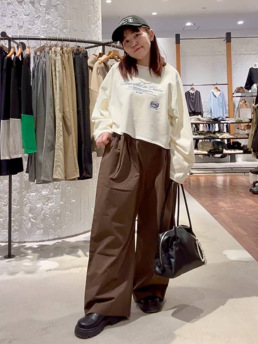 ホワイト系のTシャツ/カットソー、グリーン系のその他パンツ、ブラック系のボストンバッグを着用したレディースの冬コーディネートの8枚目の写真