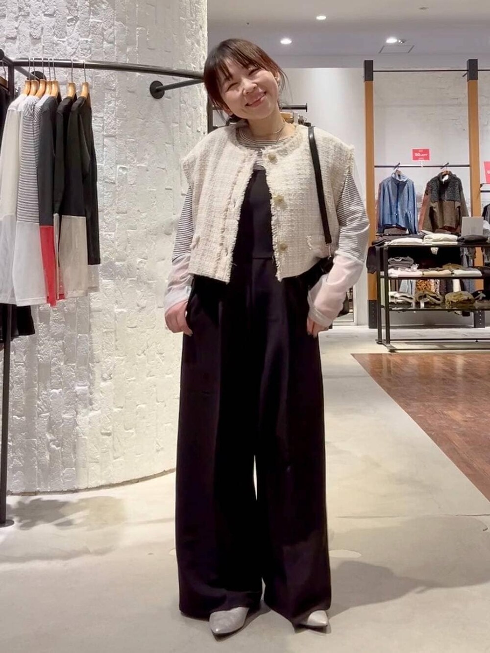 ホワイト系のTシャツ/カットソー、ブラック系のサロペット/オーバーオール、ベージュ系のその他アウターを着用したレディースの冬コーディネートの2枚目の写真