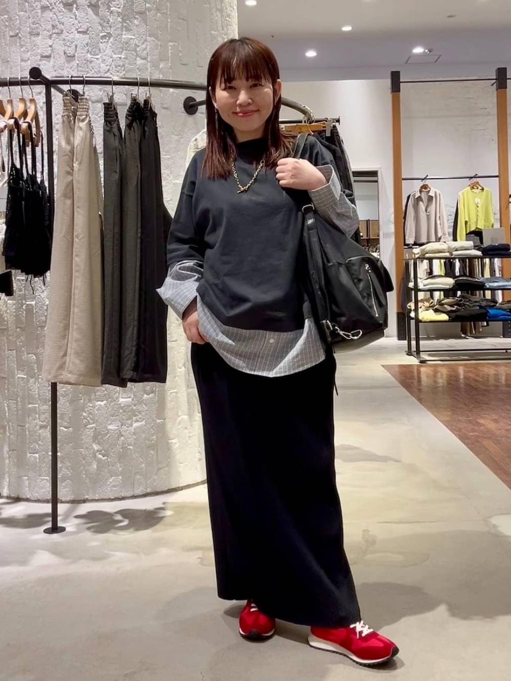 ブラック系のショルダーバッグ、レッド系のスニーカー、グレー系のTシャツ/カットソーを着用したレディースの春コーディネートの5枚目の写真