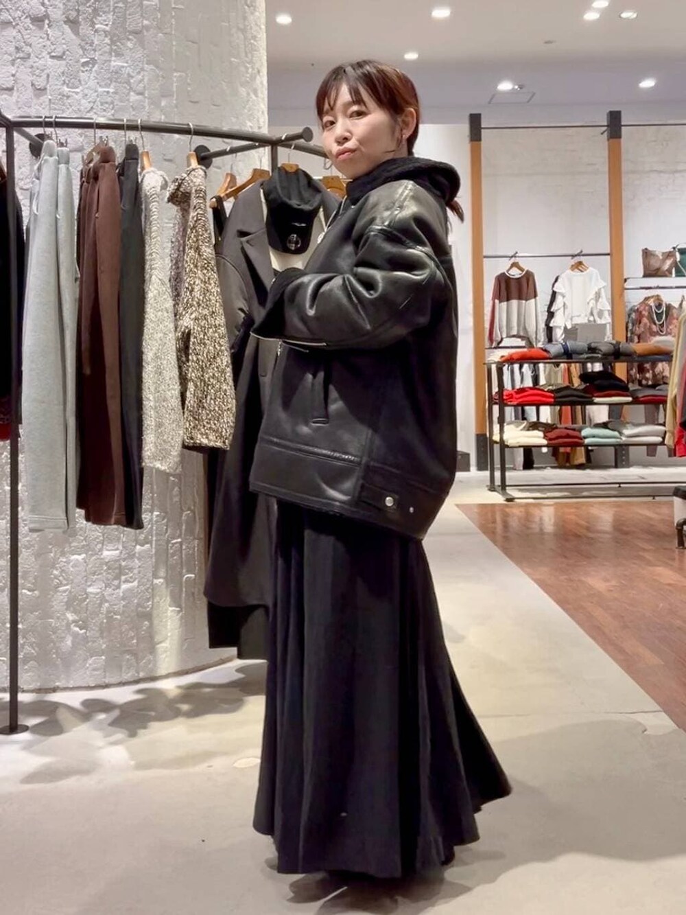 ブラック系のショルダーバッグ、ブラック系のその他アウター、ブラック系のブーツを着用したレディースの冬コーディネートの4枚目の写真