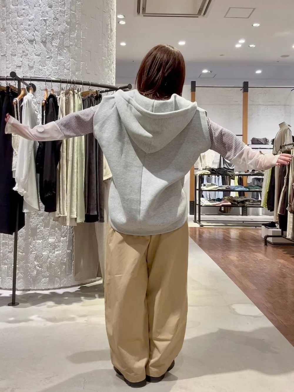 ホワイト系のTシャツ/カットソー、グレー系のベスト、ブラック系のその他シューズを着用したレディースの春コーディネートの4枚目の写真