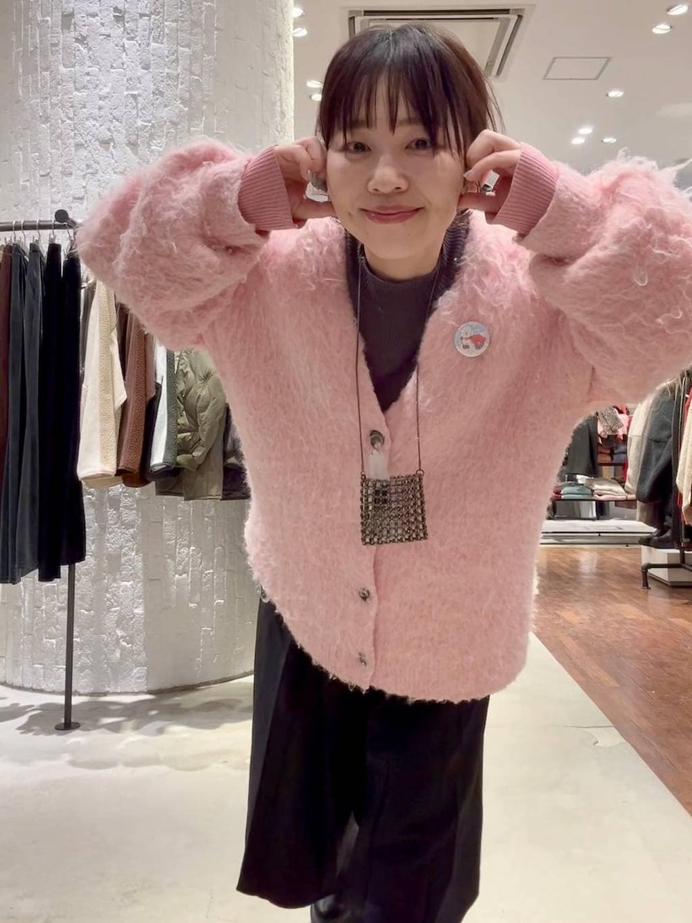 グレー系のニット/セーター、ブラック系のブーツ、ピンク系のカーディガン/ボレロを着用したレディースの冬コーディネートの5枚目の写真