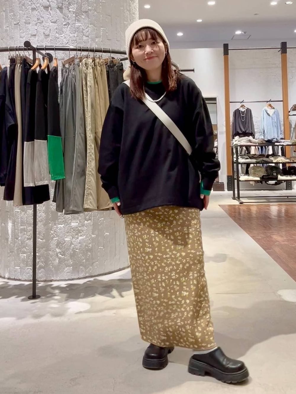 グレー系のショルダーバッグ、ブラック系のその他シューズ、ブラウン系のスカートを着用したレディースの冬コーディネートの2枚目の写真