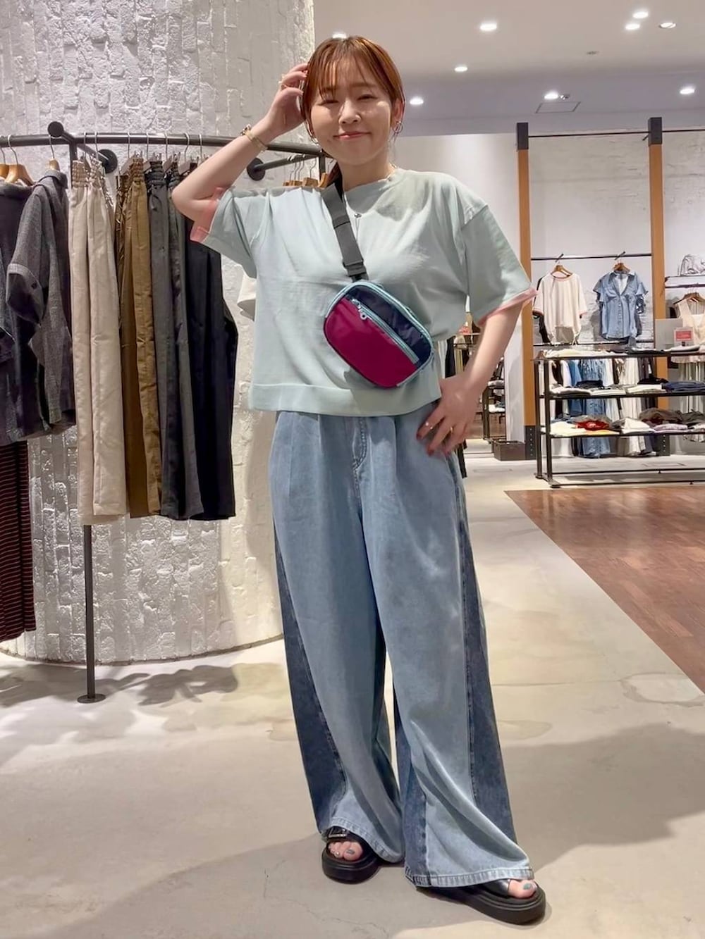 ブルー系のニット/セーター、ブルー系のデニムパンツ、ブラック系のサンダルを着用したレディースの夏コーディネートの2枚目の写真