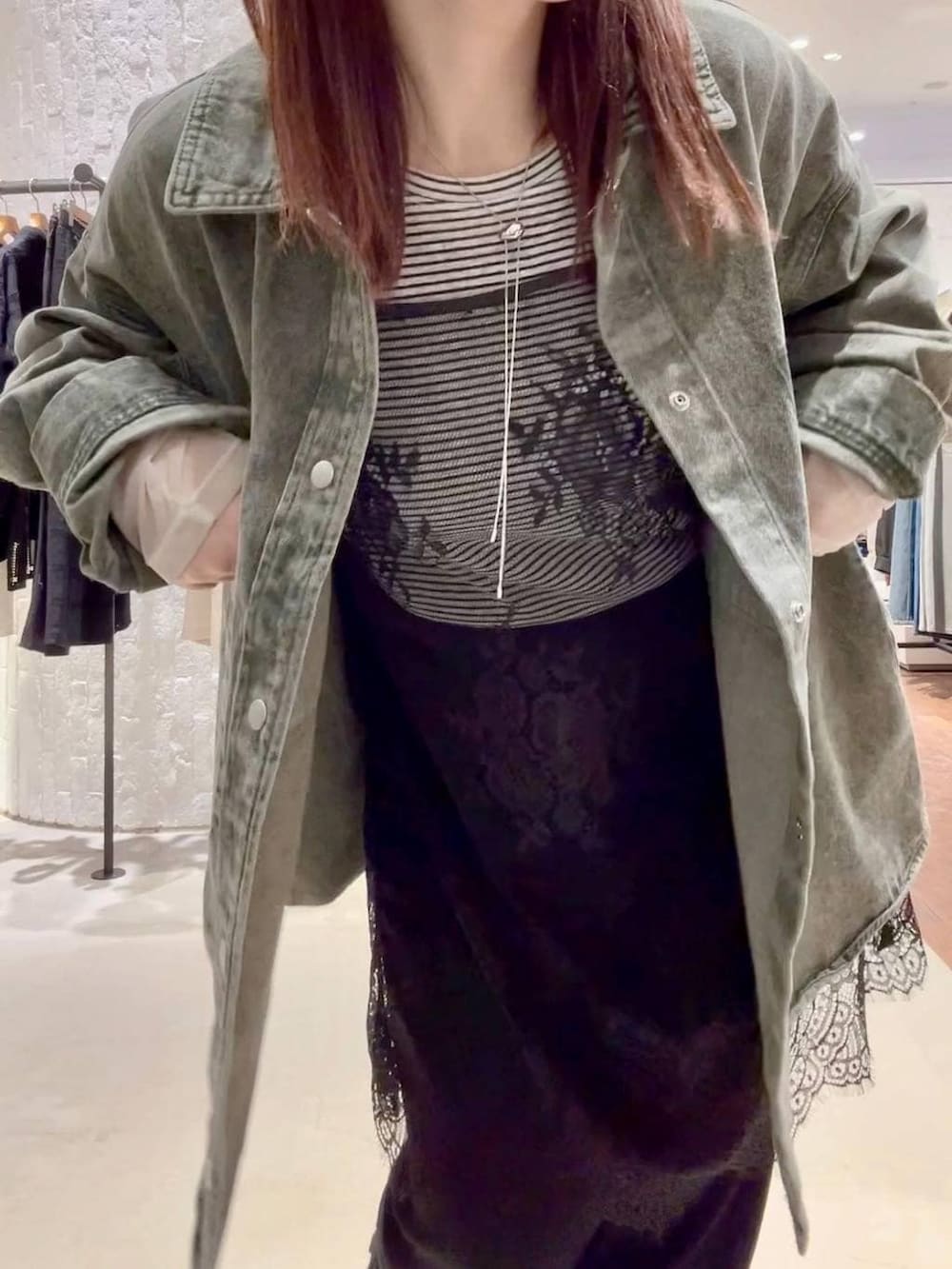 ホワイト系のTシャツ/カットソー、ブラック系のスカート、グリーン系のシャツ/ブラウスを着用したレディースの春コーディネートの6枚目の写真