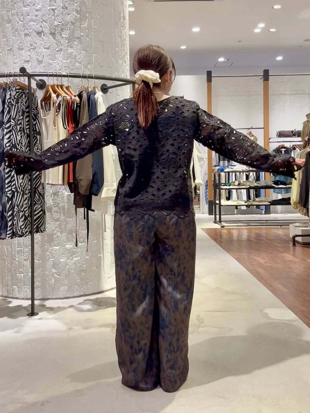 ブルー系のスニーカー、ブラウン系のその他パンツ、ブラック系のショルダーバッグを着用したレディースの春コーディネートの5枚目の写真