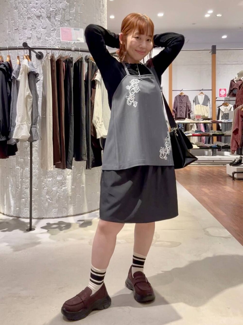 ブラウン系のローファー、ブラック系のトートバッグ、グレー系のその他パンツを着用したレディースの秋コーディネートの2枚目の写真