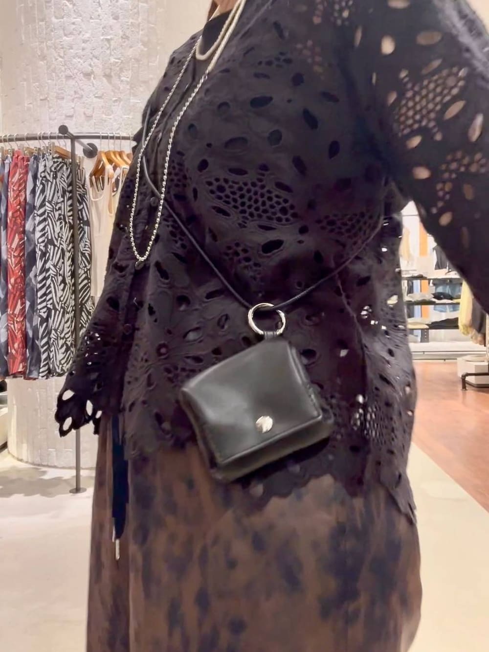ブルー系のスニーカー、ブラウン系のその他パンツ、ブラック系のショルダーバッグを着用したレディースの春コーディネートの6枚目の写真