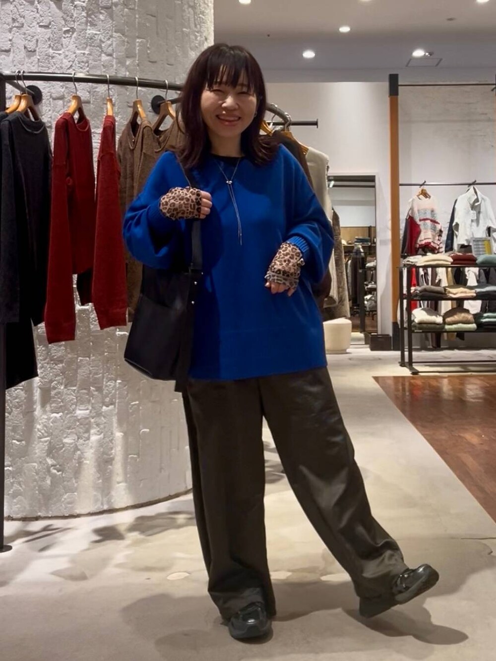 ブルー系のニット/セーター、その他のTシャツ/カットソー、ブラック系のショルダーバッグを着用したレディースの秋コーディネートの2枚目の写真