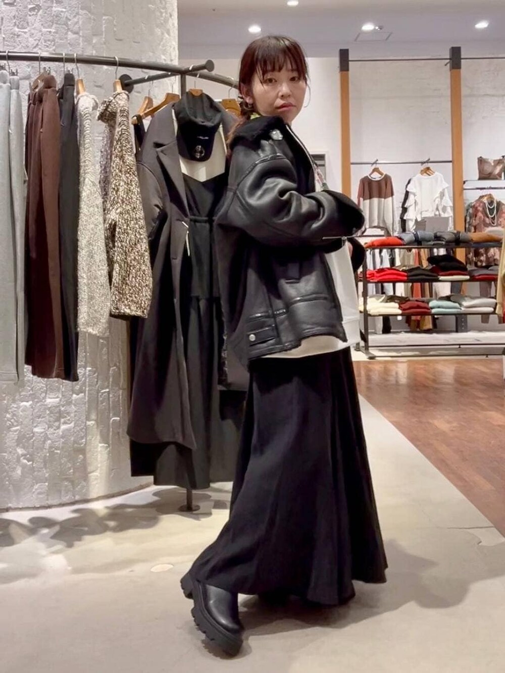 ブラック系のショルダーバッグ、ブラック系のその他アウター、ブラック系のブーツを着用したレディースの冬コーディネートの3枚目の写真