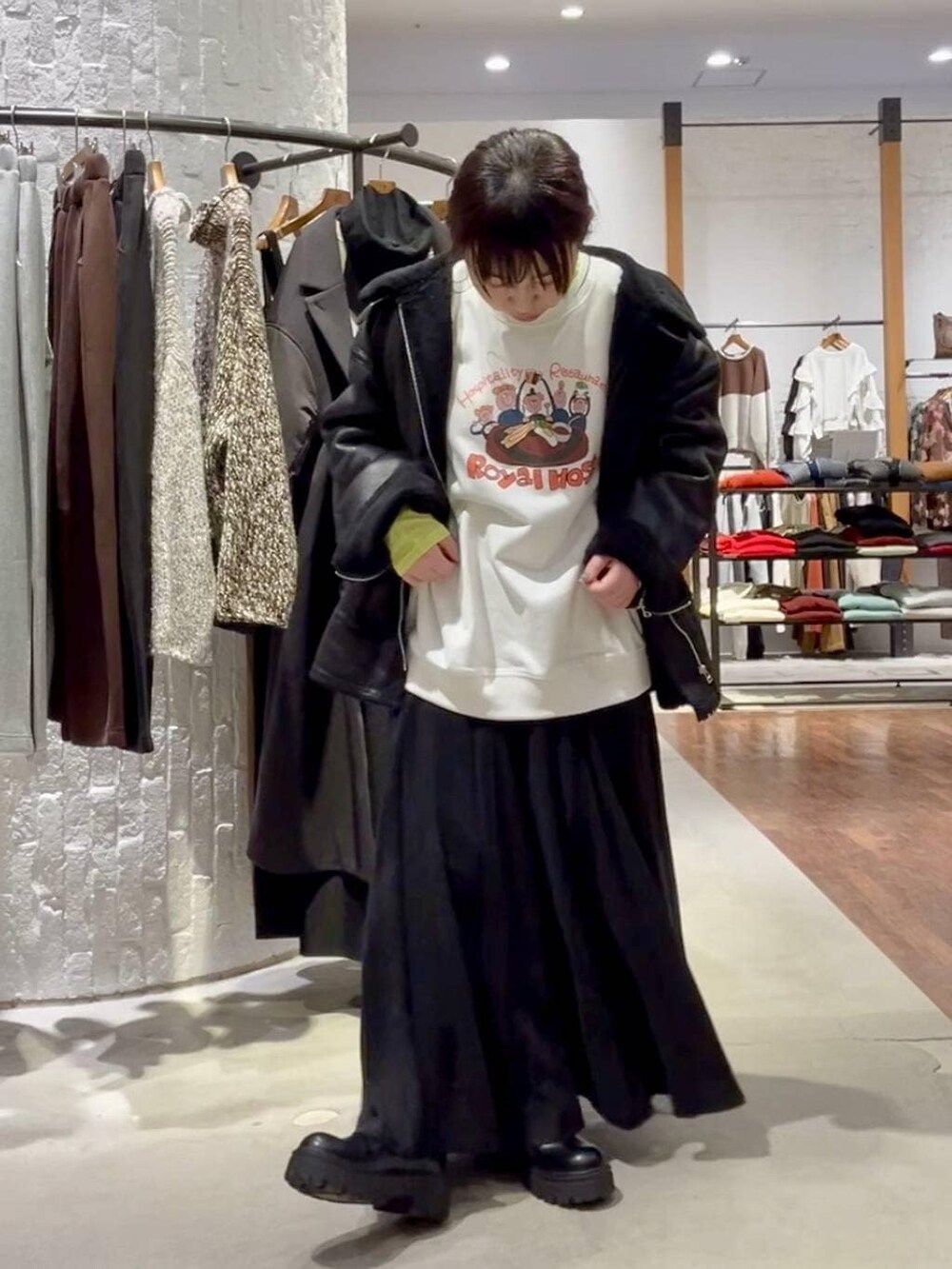 ブラック系のショルダーバッグ、ブラック系のその他アウター、ブラック系のブーツを着用したレディースの冬コーディネートの9枚目の写真