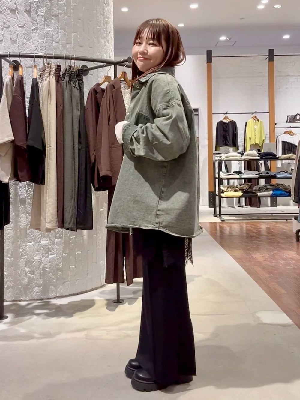 ホワイト系のTシャツ/カットソー、ブラック系のスカート、グリーン系のシャツ/ブラウスを着用したレディースの春コーディネートの3枚目の写真