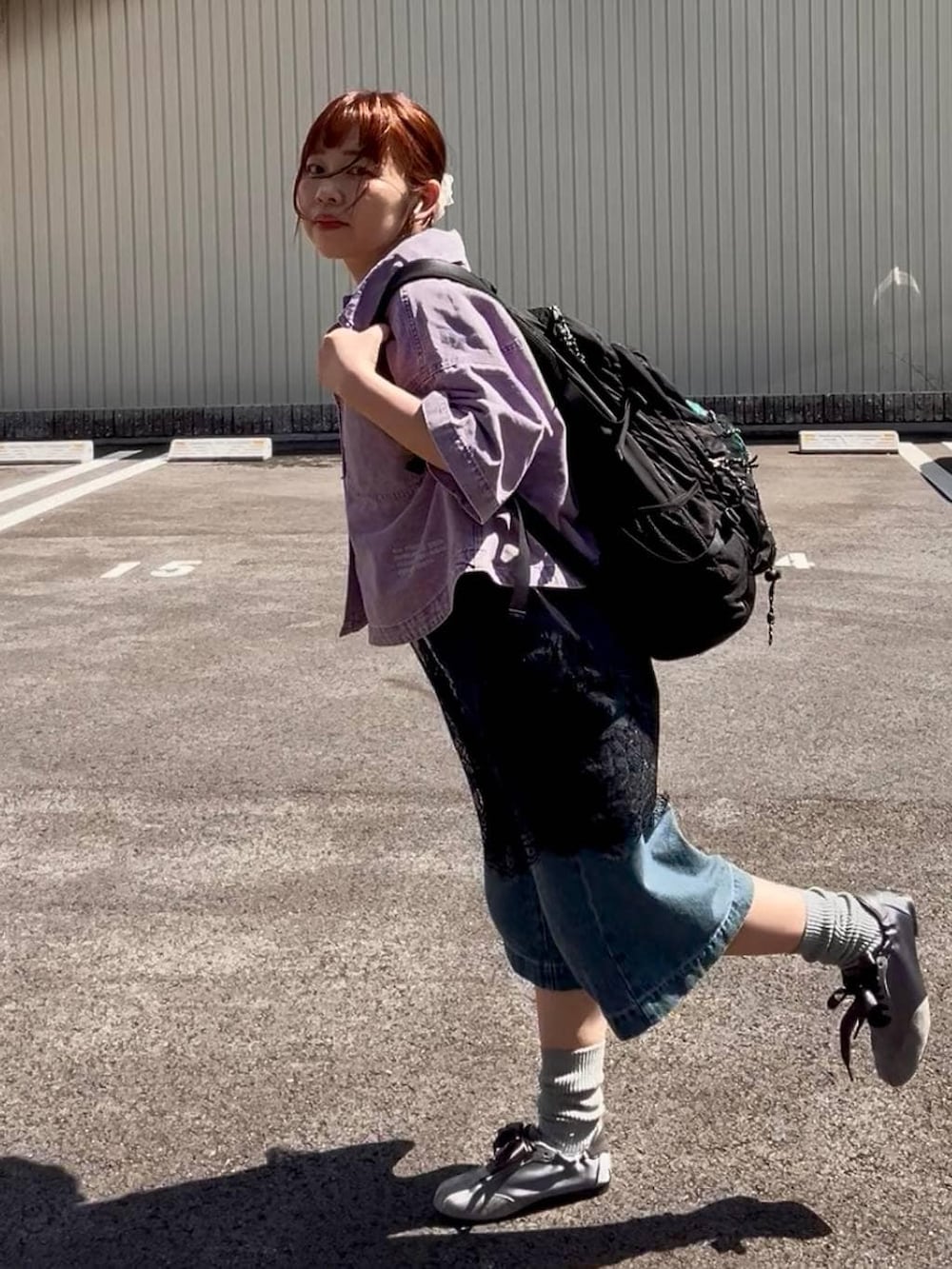ブルー系のデニムパンツ、パープル系のシャツ/ブラウス、ブラック系のキャミソールを着用したレディースの春コーディネートの2枚目の写真