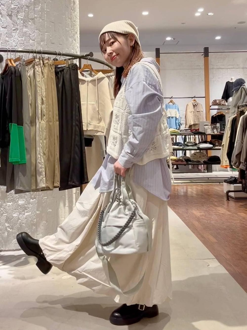 ブラック系のサンダル、ベージュ系のスカート、グレー系のショルダーバッグを着用したレディースの冬コーディネートの5枚目の写真