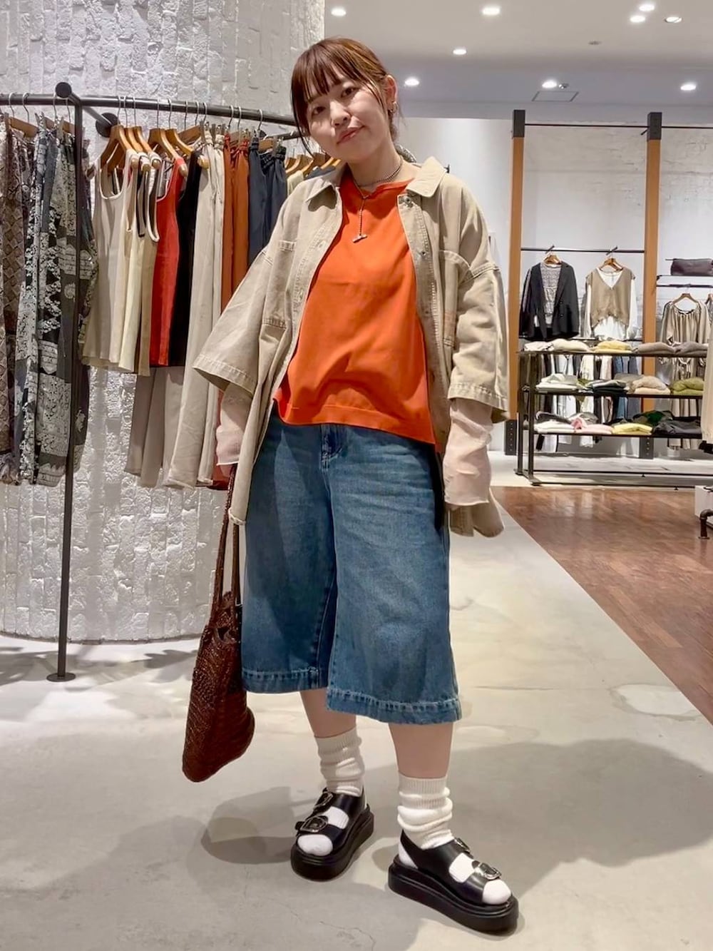 ブラック系のサンダル、ブルー系のデニムパンツ、ホワイト系のTシャツ/カットソーを着用したレディースの春コーディネートの2枚目の写真