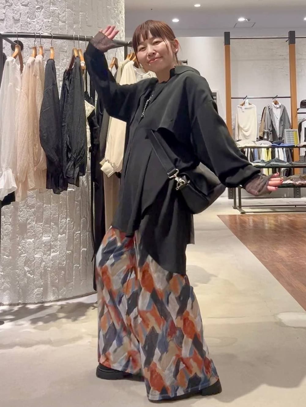 ブルー系のその他パンツ、ブラック系のショルダーバッグ、ブラック系のシャツ/ブラウスを着用したレディースの春コーディネートの6枚目の写真