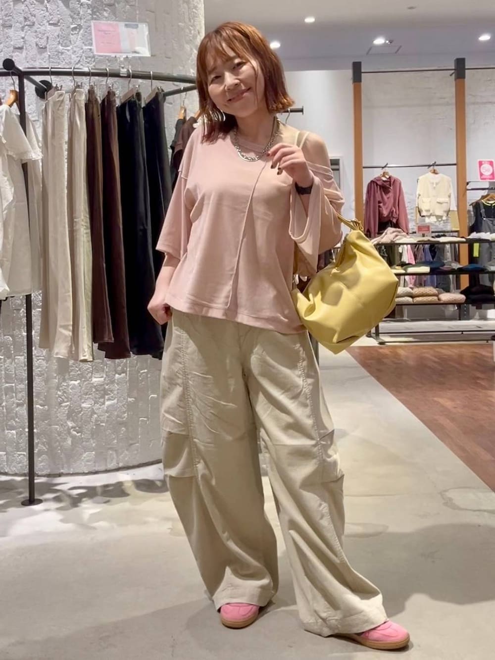 ベージュ系のその他パンツ、イエロー系のショルダーバッグ、ピンク系のTシャツ/カットソーを着用したレディースの秋コーディネートの2枚目の写真