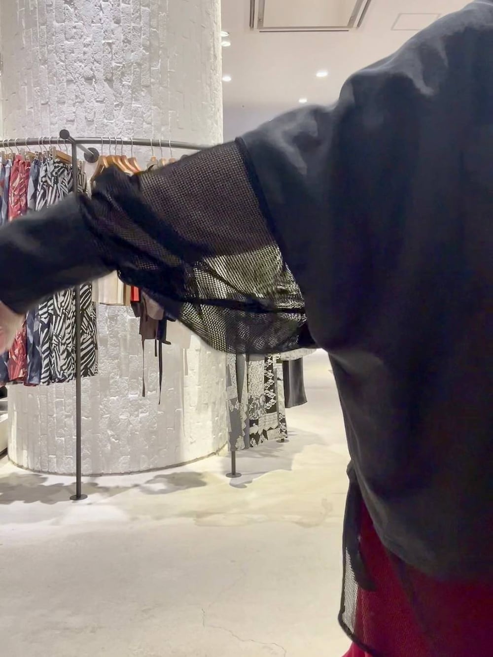 レッド系のスカート、ブルー系のスニーカー、ブラック系のボストンバッグを着用したレディースの春コーディネートの5枚目の写真