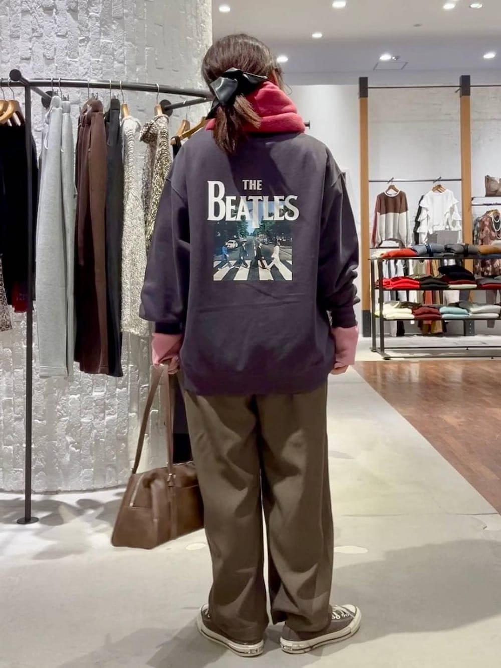 グレー系のニット/セーター、ブラウン系のスニーカー、ブラウン系のボストンバッグを着用したレディースの冬コーディネートの4枚目の写真