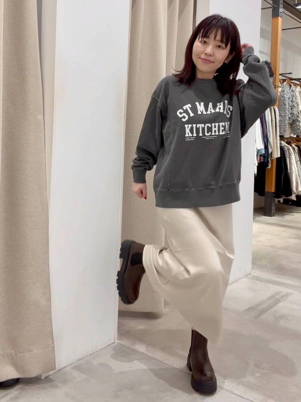 ホワイト系のスカート、ホワイト系のその他アウター、ブラウン系のブーツを着用したレディースの秋コーディネートの9枚目の写真