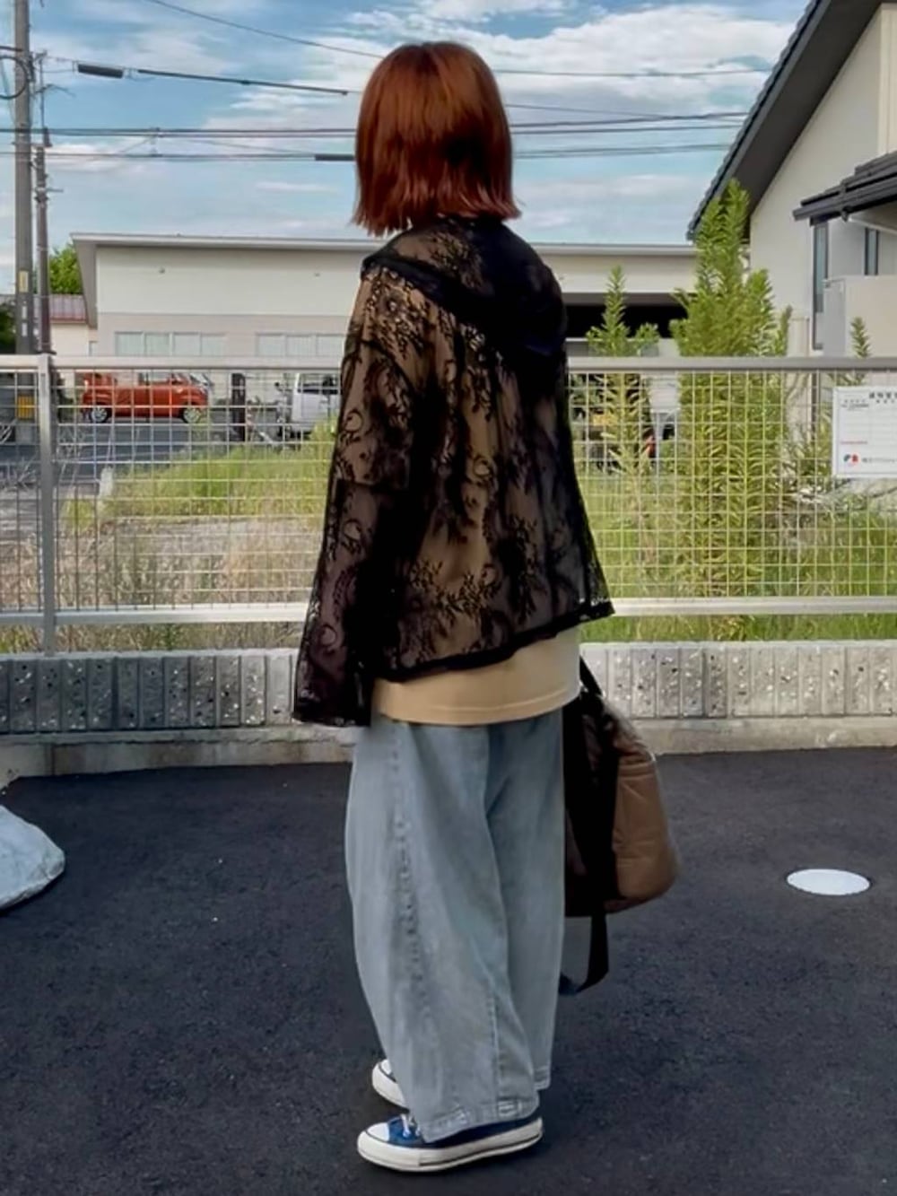 ブラック系のシャツ/ブラウス、ブルー系のスニーカー、ブルー系のデニムパンツを着用したレディースの秋コーディネートの4枚目の写真