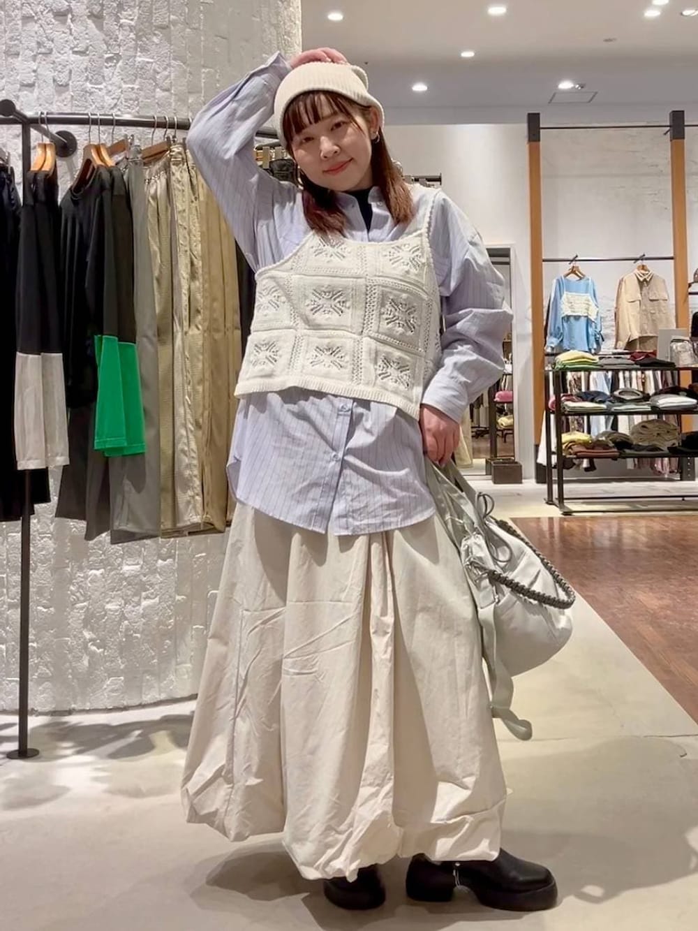 ブラック系のサンダル、ベージュ系のスカート、グレー系のショルダーバッグを着用したレディースの冬コーディネートの2枚目の写真