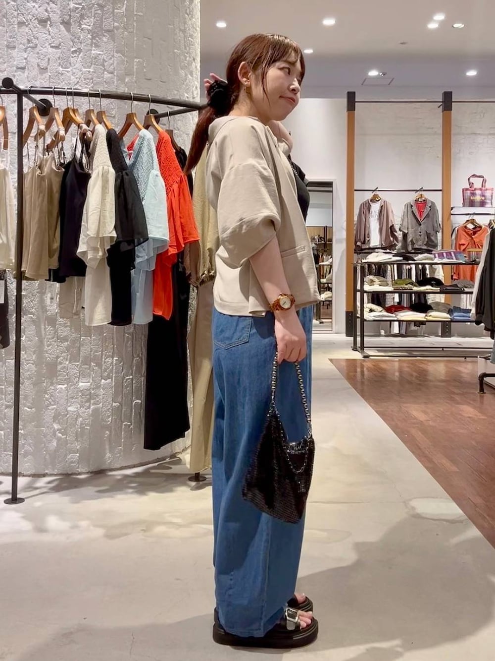 ブラック系のサンダル、ベージュ系のテーラードジャケット、ブラック系のショルダーバッグを着用したレディースの春コーディネートの3枚目の写真