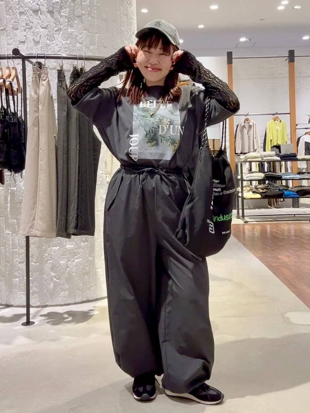 グレー系のその他パンツ、ブラック系のスニーカー、ブラック系のトートバッグを着用したレディースの春コーディネートの2枚目の写真