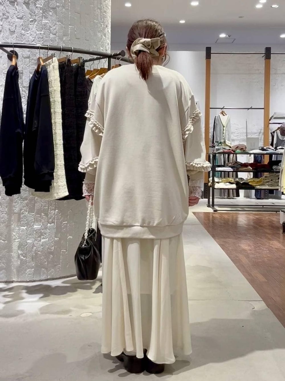 ブラック系のサンダル、ブラック系のショルダーバッグ、ホワイト系のTシャツ/カットソーを着用したレディースの冬コーディネートの4枚目の写真