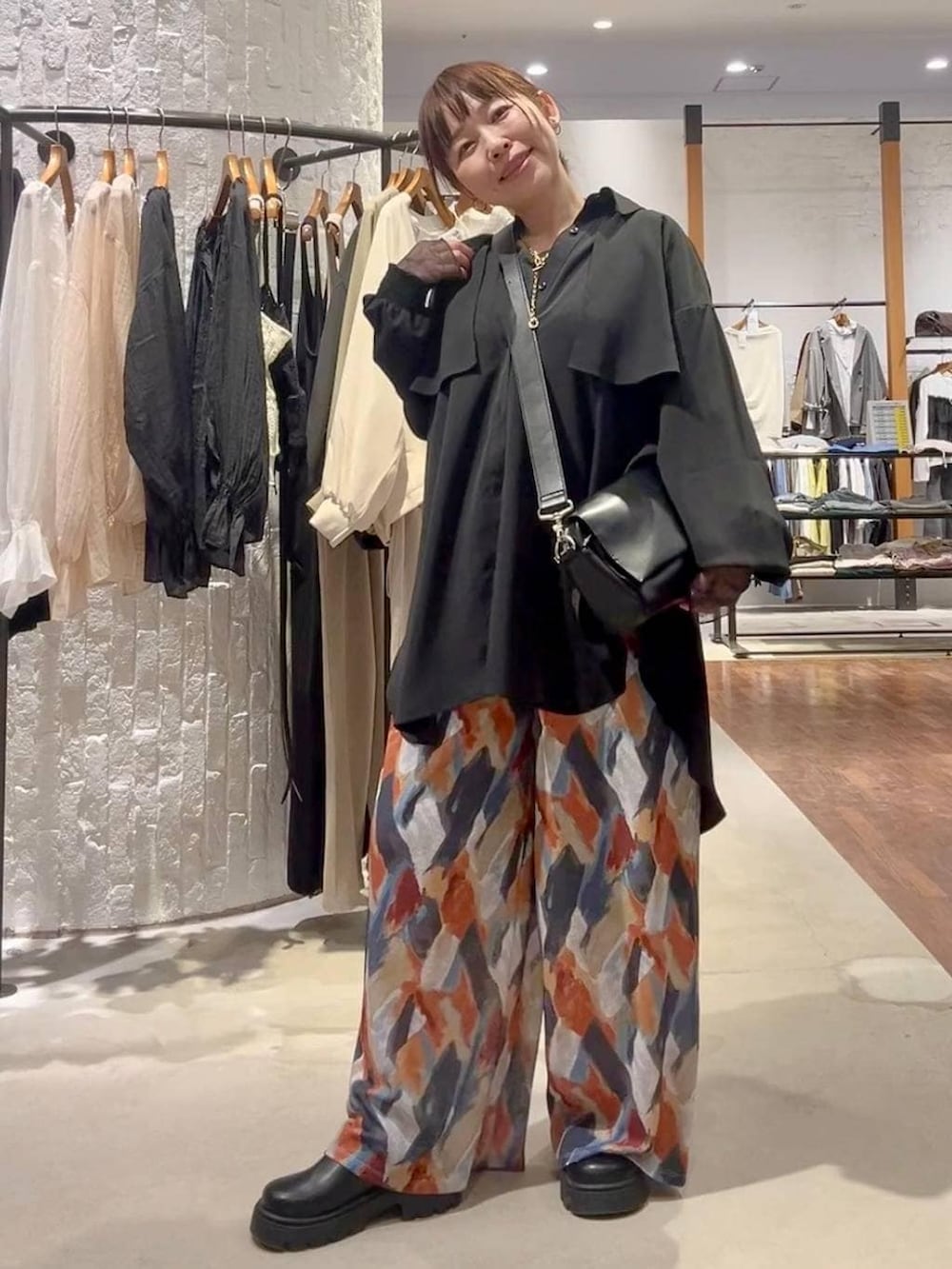 ブルー系のその他パンツ、ブラック系のショルダーバッグ、ブラック系のシャツ/ブラウスを着用したレディースの春コーディネートの2枚目の写真