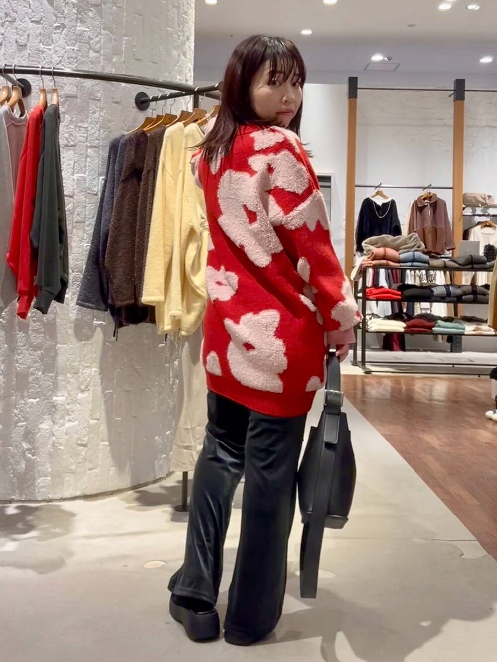 グレー系のニット/セーター、ブルー系のその他パンツ、ブラック系のショルダーバッグを着用したレディースの秋コーディネートの6枚目の写真