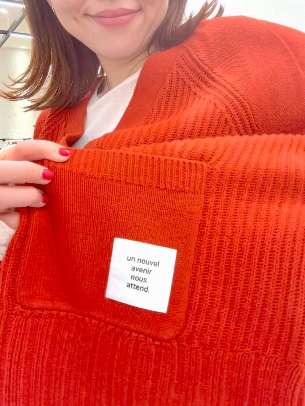 ホワイト系のTシャツ/カットソー、レッド系のカーディガン/ボレロ、ブルー系のスニーカーを着用したレディースの秋コーディネートの5枚目の写真