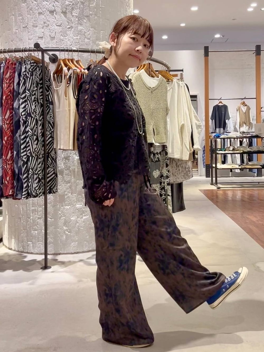 ブルー系のスニーカー、ブラウン系のその他パンツ、ブラック系のショルダーバッグを着用したレディースの春コーディネートの4枚目の写真