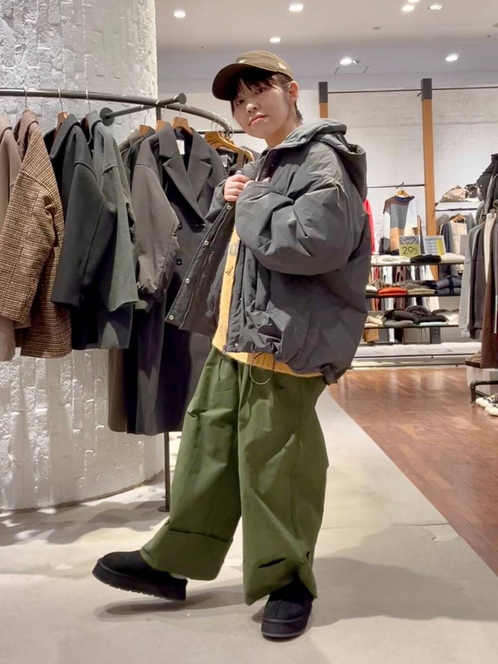 グレー系のその他アウター、グリーン系のその他パンツ、イエロー系のニット/セーターを着用したレディースの秋コーディネートの2枚目の写真