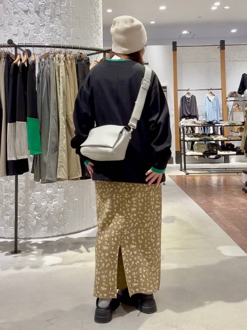 グレー系のショルダーバッグ、ブラック系のその他シューズ、ブラウン系のスカートを着用したレディースの冬コーディネートの4枚目の写真