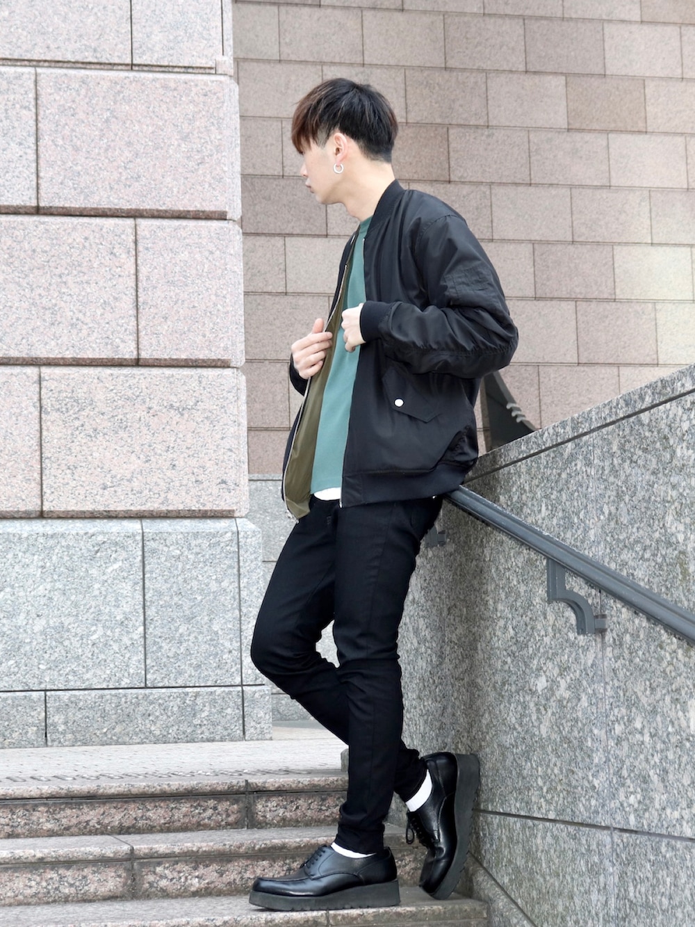 グリーン系のMA-1、グリーン系のニット/セーター、ブラック系のデニムパンツを着用したメンズの春コーディネートの2枚目の写真