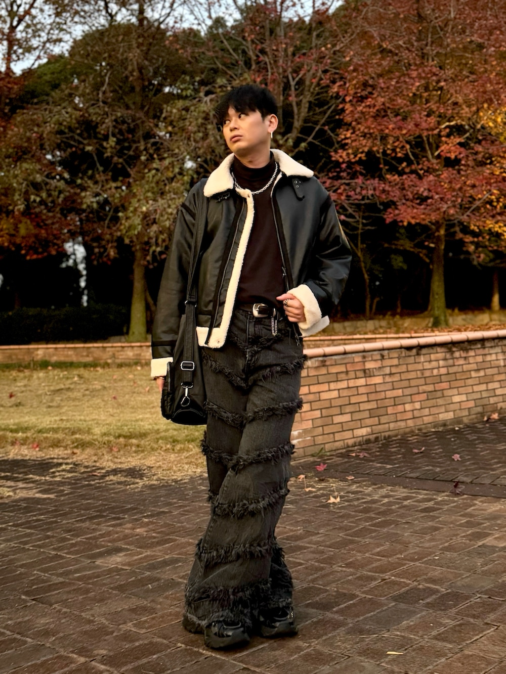 ブラック系のブルゾン、ブラック系のデニムパンツ、ブラック系のショルダーバッグを着用したメンズの秋コーディネートの2枚目の写真