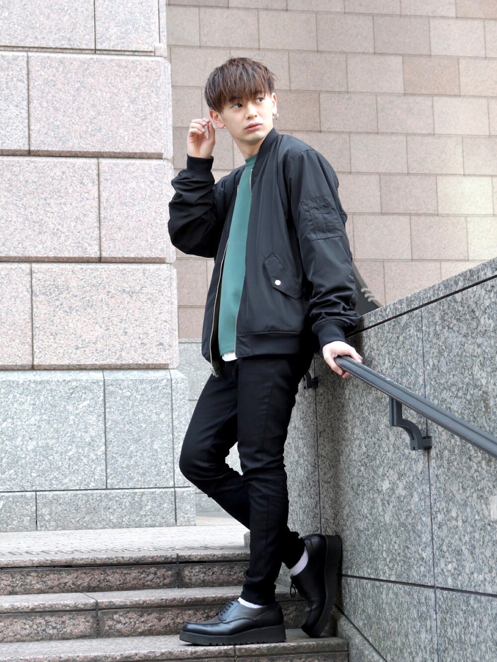 グリーン系のMA-1、グリーン系のニット/セーター、ブラック系のデニムパンツを着用したメンズの春コーディネートの3枚目の写真