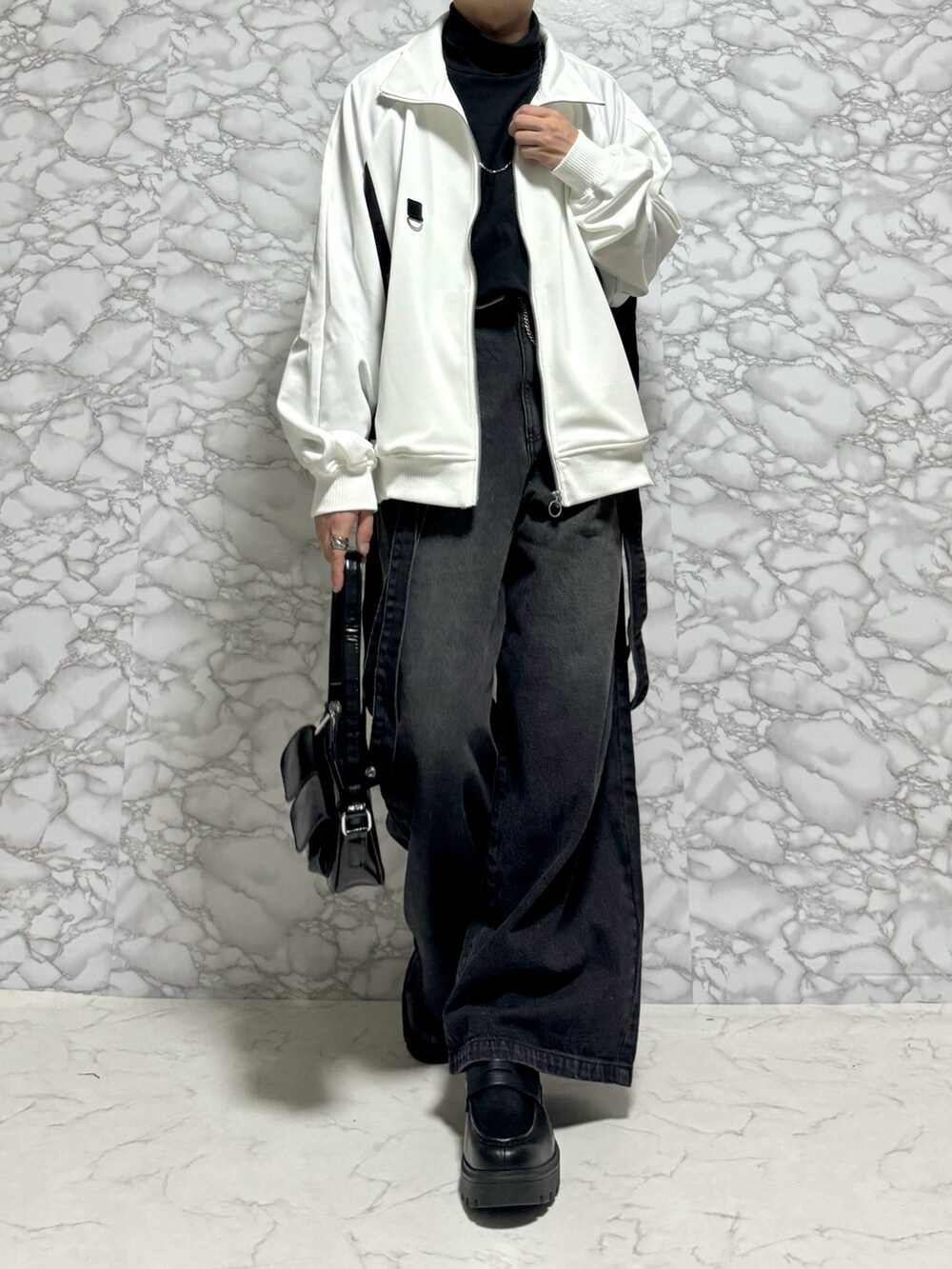 ホワイト系のブルゾン、グレー系のデニムパンツ、シルバー系のネックレスを着用したメンズの秋コーディネートの2枚目の写真
