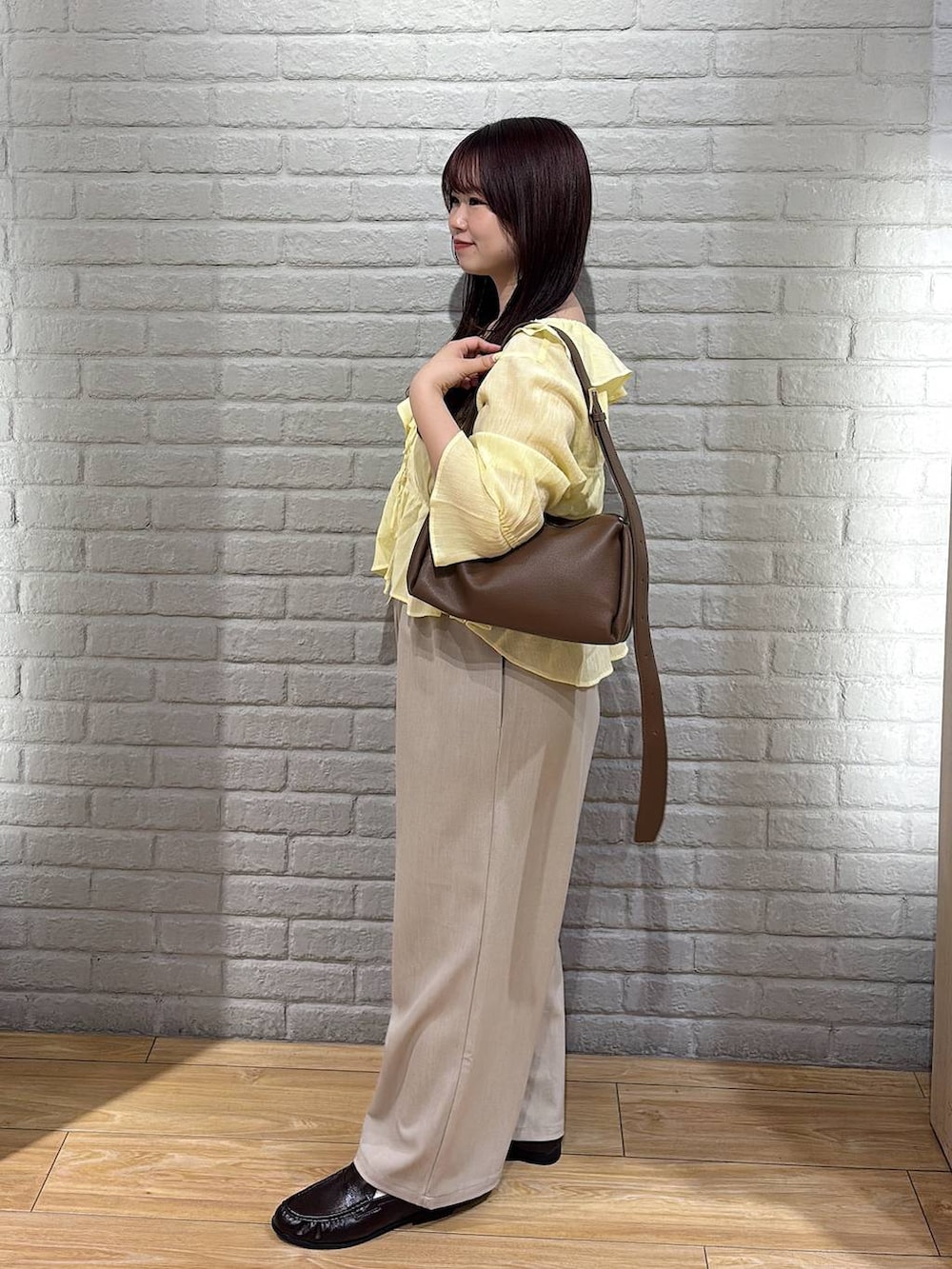 ベージュ系のその他パンツ、ブラウン系のローファー、イエロー系のシャツ/ブラウスを着用したレディースの夏コーディネートの2枚目の写真