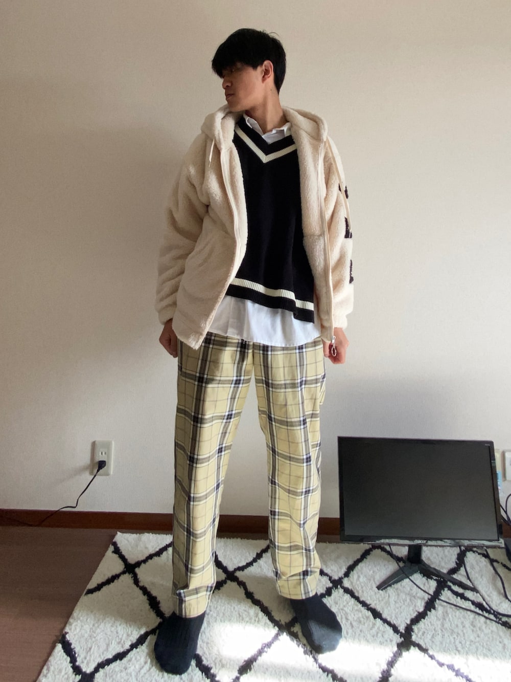 ベージュ系のパンツ、ブラック系のベスト、ホワイト系のシャツ/ブラウスを着用したメンズの春コーディネートの2枚目の写真