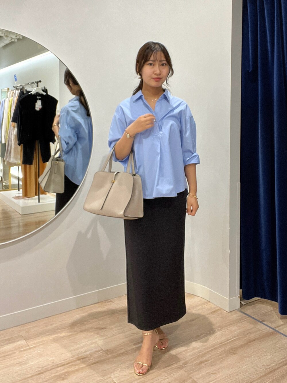 ブルー系のシャツ/ブラウス、ブラック系のスカートを着用したレディースの夏コーディネートの2枚目の写真