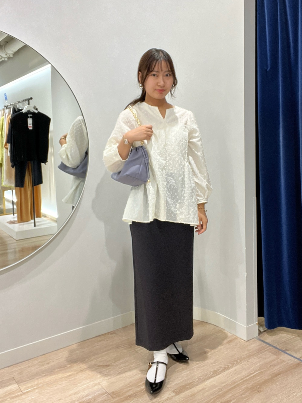 ホワイト系のシャツ/ブラウス、パープル系のショルダーバッグ、ブラック系のスカートを着用したレディースの夏コーディネートの2枚目の写真
