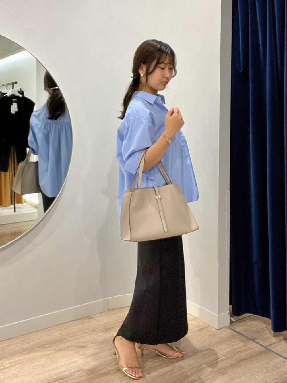 ブルー系のシャツ/ブラウス、ブラック系のスカートを着用したレディースの夏コーディネートの4枚目の写真