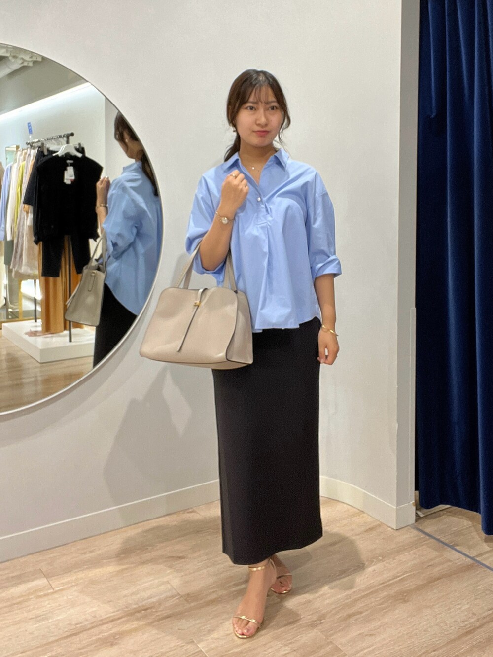 ブルー系のシャツ/ブラウス、ブラック系のスカートを着用したレディースの夏コーディネートの3枚目の写真