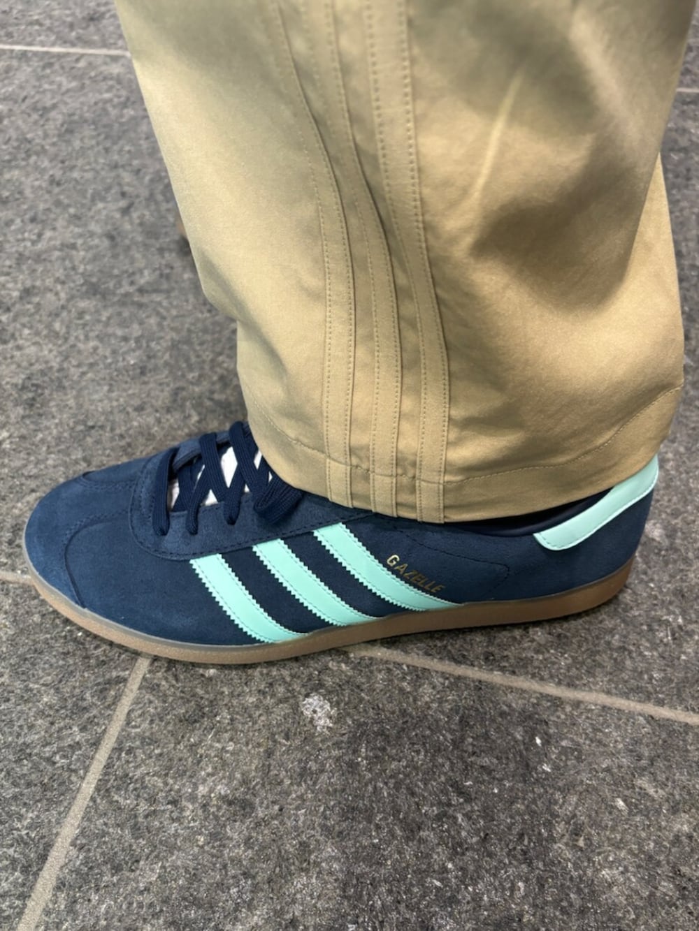 ホワイト系のポロシャツ、ベージュ系のその他パンツ、ブルー系のスニーカーを着用したメンズの冬コーディネートの2枚目の写真